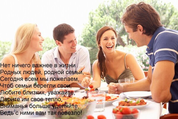 Счастливые молодые люди за семейным обедом на природе. Вдохновляющая цитата о любви, уважении и важности близких людей и семейных ценностей. Открытка Нет ничего важнее в жизни Родных людей, родной семьи, Сегодня всем мы пожелаем, Чтоб семьи берегли с Группа молодых счастливых людей — двух пар — сидит за столом на открытом воздухе и наслаждается совместной трапезой. На изображении запечатлен момент искреннего смеха, общения и душевного единения. На фоне наложена трогательная цитата о важности семьи, любви к близким и уважении к родным людям. Атмосфера снимка передает тепло, уют и ценность семейных ценностей