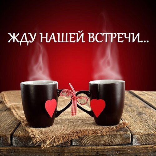 Романтичное фото двух кружек с сердцами и надписью «Жду нашей встречи...». Уютная атмосфера, пар над напитком и красный фон для выражения чувств. Открытка Жду нашей встречи... Уютное и романтичное изображение двух черных кружек с горячим напитком, стоящих на деревянном столе на фоне красного цвета. На каждой кружке красуется красное сердце, а между ручками завязан красно-белый бант. Над кружками поднимаются струйки пара, создавая атмосферу тепла. На фоне расположена надпись на русском языке: «ЖДУ НАШЕЙ ВСТРЕЧИ...»