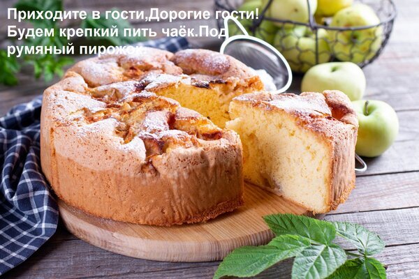 Домашний яблочный пирог с золотистой корочкой на деревянной доске. Свежая выпечка, уют и аромат яблок для ваших рецептов и кулинарных идей. Открытка Приходите в гости, Дорогие гости! Будем крепкий пить чаек Под румяный пирожок. Аппетитный домашний яблочный пирог с золотистой корочкой, поданный на деревянной доске. На снимке крупным планом запечатлен свежеиспеченный бисквитный пирог, из которого отрезан кусочек, демонстрируя нежную текстуру. На заднем плане видны свежие зеленые яблоки в металлической корзине и уютная домашняя обстановка