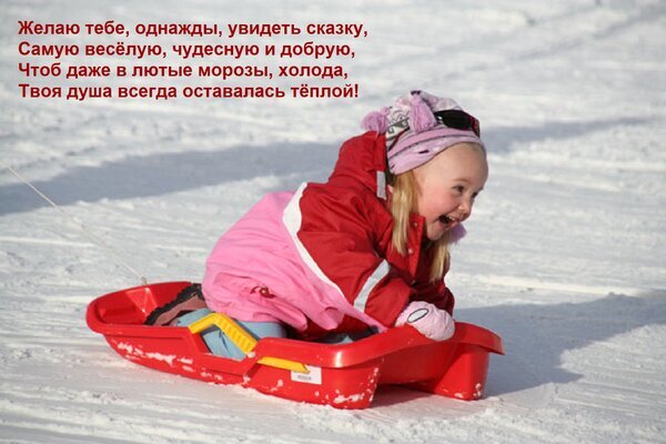 Маленькая девочка весело катается на санках по снегу. Трогательная зимняя открытка с добрым пожеланием: «Чтоб даже в лютые морозы, душа всегда оставалась теплой!» Открытка Желаю тебе, однажды, увидеть сказку, Самую веселую, чудесную и добрую, Чтоб даже в лютые морозы, хол Эмоциональное зимнее изображение маленькой девочки, весело катающейся на красных санках по заснеженному склону. Ребенок одет в теплую розово-красную зимнюю одежду и рад зимним забавам. На картинке наложен трогательный текст на русском языке с пожеланием, чтобы душа всегда оставалась теплой, несмотря на морозы