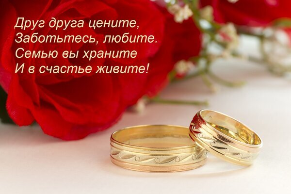 Золотые обручальные кольца и красные розы с трогательным стихом о любви и семейном счастье. Романтическая открытка для свадьбы или годовщины. Открытка Друг друга цените, Заботьтесь, любите. Семью вы храните И в счастье живите! Романтическое изображение двух золотых обручальных колец на светлом фоне в окружении пышных красных роз. На картинке нанесен трогательный стих о любви, заботе и семейном счастье на русском языке. Идеально подходит для тематики свадеб, годовщины свадьбы, романтических поздравлений и выражения чувств