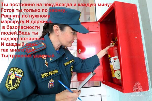 Сотрудница МЧС России проверяет огнетушитель в пожарном шкафу. Фотография посвящена службе спасателей, их готовности и защите людей от пожаров. Открытка Ты постоянно на чеку, Всегда и каждую минуту, Готов ты только по звонку, Рвануть по нужному маршруту На изображении представлена женщина в форме сотрудника МЧС России, работающая с оборудованием пожарной безопасности. Она находится рядом с открытым красным шкафом, в котором расположен огнетушитель. На форме видны шевроны с надписью «МЧС России». На фоне наложен торжественный текст в стихах, посвященный самоотверженному труду пожарных и спасателей, их постоянной готовности к работе и ответственности за безопасность людей