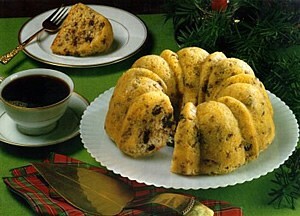 Вкусный домашний кекс с изюмом и чашка ароматного кофе на праздничном столе. Идеальное сочетание для уютного завтрака или рождественского чаепития. Открытка Торт пирог саварен На фотографии представлен аппетитный домашний кекс в форме кольца (бундт), украшенный изюмом или кусочками шоколада, поданный на белой тарелке. Рядом стоит чашка горячего черного кофе, создавая уютную атмосферу для завтрака или чаепития. На заднем плане видны веточки хвои, что придает снимку праздничное, рождественское настроение