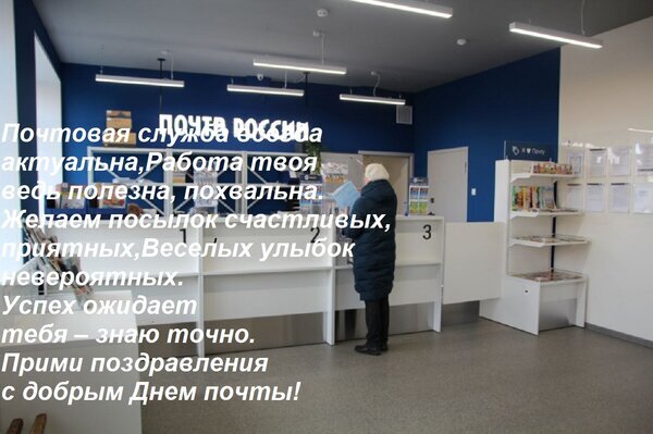 Интерьер отделения Почты России с поздравительным текстом к Дню почты. Человек у стойки обслуживания, современный дизайн офиса. Открытка Почтовая служба всегда актуальна, Работа твоя ведь полезна, похвальна. Желаем посылок счастливых, п Интерьер современного отделения Почты России с белыми стойками обслуживания и синими стенами. На переднем плане человек в синей куртке стоит у операционного окна. На изображении наложен поздравительный текст на русском языке, адресованный сотрудникам почтовой службы, с пожеланиями успехов и счастья в честь Дня почты