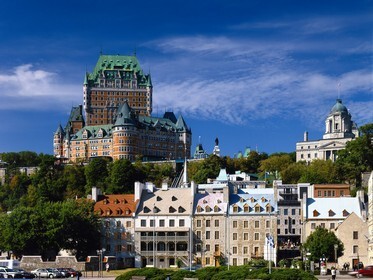 Знаменитый отель Château Frontenac в Квебеке. Величественная архитектура старого города на фоне голубого неба. Живописный вид для любителей путешествий. Открытка Город квебек канада Величественный вид на исторический отель Fairmont Le Château Frontenac в Квебеке, Канада. На фотографии запечатлено роскошное здание в стиле шато в стиле архитектуры с характерными зелеными крышами, возвышающееся над живописным старым городом. На переднем плане видны уютные каменные дома и зелень, а на заднем плане — чистое голубое небо с легкими облаками