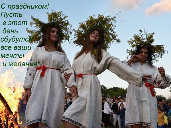 Поздравление с праздником: девушки в народных костюмах и венках на фоне костра и заката. Тематика: славянские традиции, Иван Купала, лето. Открытка С праздником! Пусть в этот день сбудутся все ваши мечты и желания! Коллаж, посвященный славянским народным традициям и праздникам природы. На изображении три молодые девушки в традиционных белых вышитых рубахах с красными поясами и пышными венками из полевых трав и цветов на головах. Девушки танцуют на фоне заката и праздничного костра, создавая атмосферу древнего обряда. На картинке размещен поздравительный текст на русском языке:  С праздником! Пусть в этот день сбудутся все ваши мечты и желания!