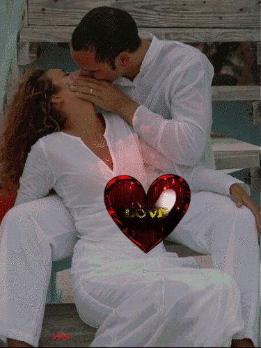 Романтичное фото влюбленной пары в белом с красным сердцем и надписью LOVE. Идеально для тем любви, свиданий и праздника Дня святого Валентина. Анимированная открытка Как хорошо целуются Романтическое изображение пары в белых одеждах, выражающей свои чувства через нежный поцелуй. Мужчина наклоняется к женщине, создавая атмосферу любви и близости. В центре композиции расположен яркий красный глянцевый символ сердца с надписью 