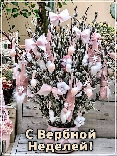 Праздничный букет из вербы с розовыми бантами и декоративными гномами. Поздравление с Вербной неделей в нежных весенних тонах. Открытка С вербной неделей! Красивый праздничный букет из пушистых веточек вербы, украшенный нежно-розовыми бантами, декоративными фигурками гномов и цветами. Композиция символизирует наступление весны и празднование Вербного воскресенья. На картинке представлен уютный весенний декор в пастельных тонах, создающий торжественное и светлое настроение. Текст на изображении гласит: «С Вербной Неделей!»