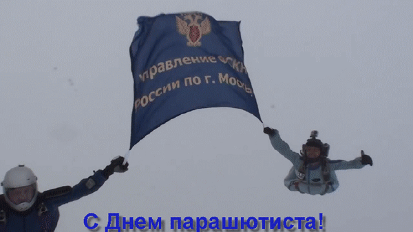 Парашютисты в небе держат большой синий флаг. Поздравление «С Днем парашютиста!». Экстремальный спорт, прыжки с парашютом и командная работа. Анимированная открытка С днем парашютиста! На изображении запечатлен захватывающий момент прыжка с парашютом: два парашютиста в небе удерживают большой синий флаг с золотистой надписью на русском языке. На фоне пасмурного неба виден текст поздравления «С Днем парашютиста!». Кадр передает дух экстремального спорта, командной работы и торжественности момента