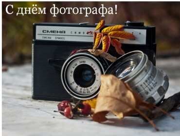 Поздравление с Днем фотографа: винтажный фотоаппарат «Смена», осенние листья и ягоды. Эстетичная ретро-открытка для любителей аналоговой фотографии. Открытка С днем фотографа! Поздравление с Днем фотографа с эстетичным осенним настроением. На снимке изображен винтажный пленочный фотоаппарат «Смена», лежащий на деревянной поверхности в окружении золотых осенних листьев и ягод. Атмосферное фото в ретро-стиле, идеально подходящее для тематических открыток, постов в социальных сетях и поздравлений профессионалов фотоискусства