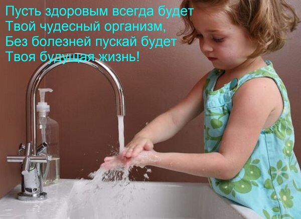 Маленькая девочка моет руки, заботясь о гигиене. Изображение на тему детского здоровья, чистоты и формирования полезных привычек с раннего возраста. Открытка Пусть здоровым всегда будет Твой чудесный организм, Без болезней пускай будет Твоя будущая жизнь! На изображении запечатлен милый момент: маленькая девочка в зеленом платье с цветочным принтом моет руки под струей воды из крана. Фотография передает атмосферу чистоты, заботы о здоровье и формирования полезных привычек с раннего детства. Поверх изображения наложен вдохновляющий текст на русском языке с пожеланием здоровья и крепкого организма