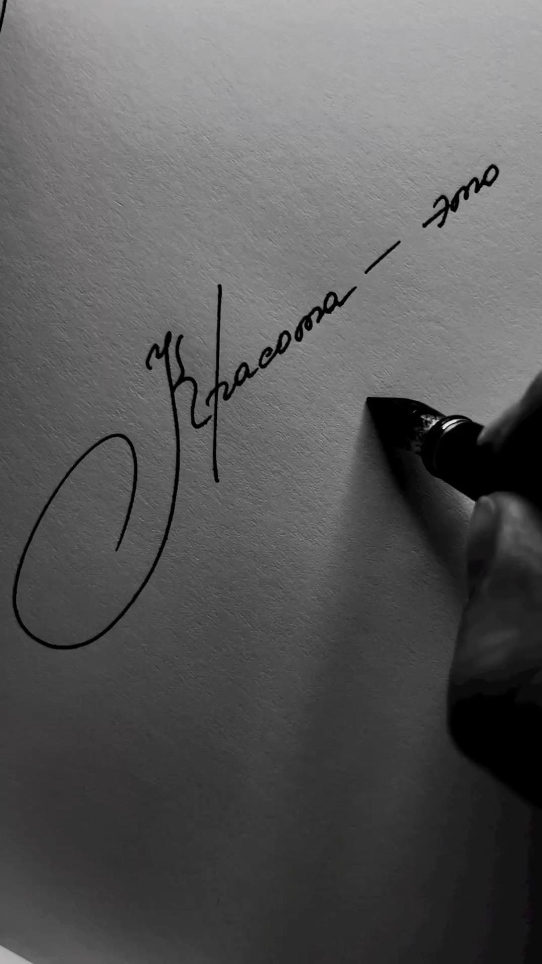 Пожелания на каждый день. Красота - это... a person writing on a piece of paper with a black ink pen in their left hand