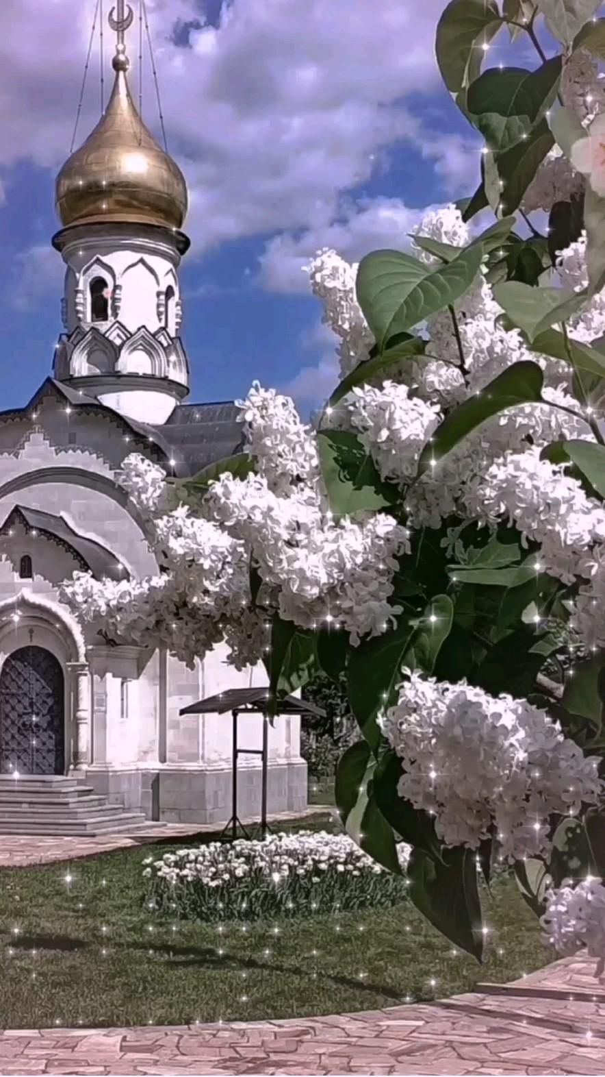 Открытка на Благовещенье. Благовещение a large white building with a gold dome and flowers in the foreground on a sunny day