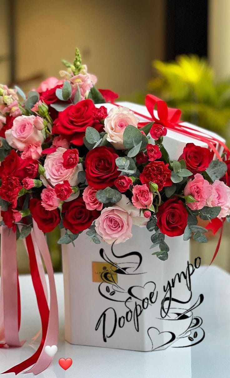 Открытка с добрым утром. red and pink flowers in a white box on a table with a ribbon around it