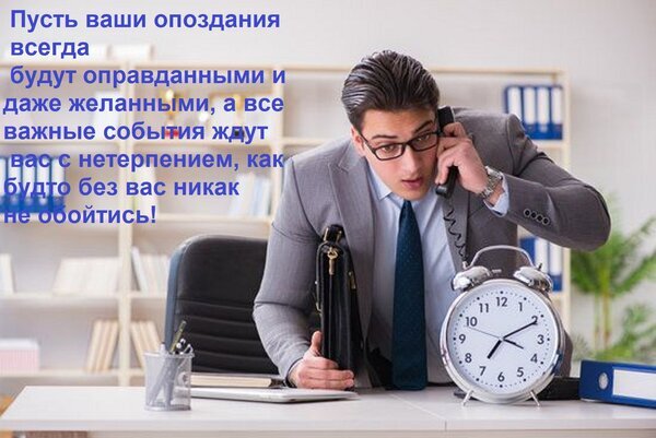 Деловой мужчина за работой с будильником на столе. Мотивационная картинка на тему времени, бизнеса и тайм-менеджмента с текстом на русском языке. Открытка Пусть ваши опоздания всегда будут оправданными и даже желанными, а все важные события ждут вас с не Изображение в стиле бизнес-мотивации: молодой мужчина в деловом костюме и очках, находясь в офисе, ведет напряженный телефонный разговор. На переднем плане на столе стоит большой будильник, акцентирующий внимание на теме времени, дедлайнов и пунктуальности. На фоне виден офисный интерьер с полками и папками