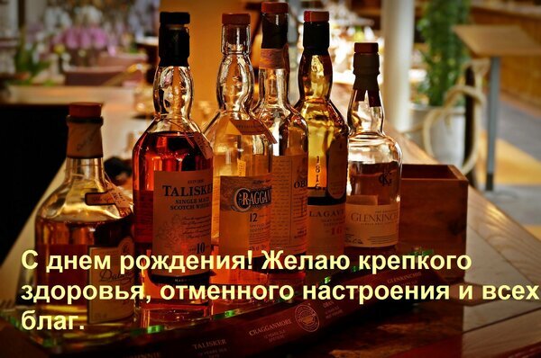 Поздравление с днем рождения на фоне бутылок элитного шотландского виски. Текст: «С днем рождения! Желаю крепкого здоровья, отличного настроения и всех благ.» Открытка С днем рождения! Желаю крепкого здоровья, отменного настроения и всех благ. Фотография группы бутылок с премиальным шотландским виски (включая Talisker, Lagavulin, Glenkinchie и другие) на деревянном столе