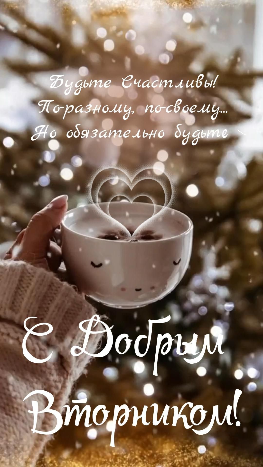 Открытка на вторник. 💜 a person holding a cup with two hearts on it in front of a christmas tree