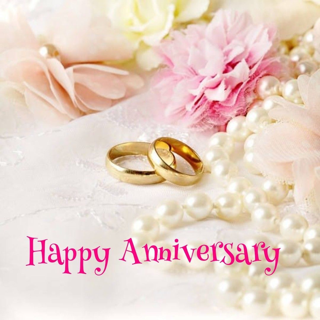 Открытка с годовщиной свадьбы. Happy Aniversary two wedding rings sitting next to flowers and pearls
